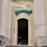 L�edificio del 1912 presenta un portale inscritto in una successione di archi a tutto sesto concentrici, ai quali corrispondono altrettante coppie di semicolonne